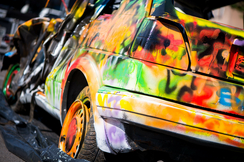 Bild zeigt ein mit Graffiti besprühtes Auto 